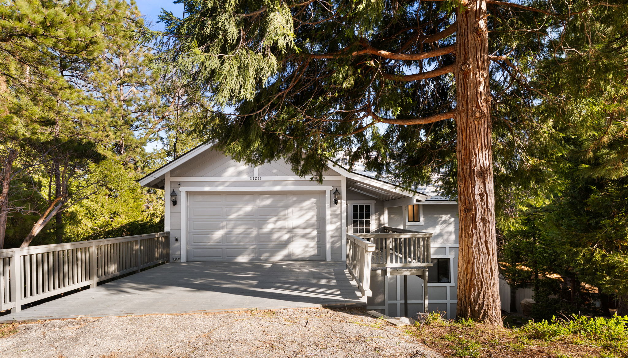 Level driveway, garage, and wooded approach