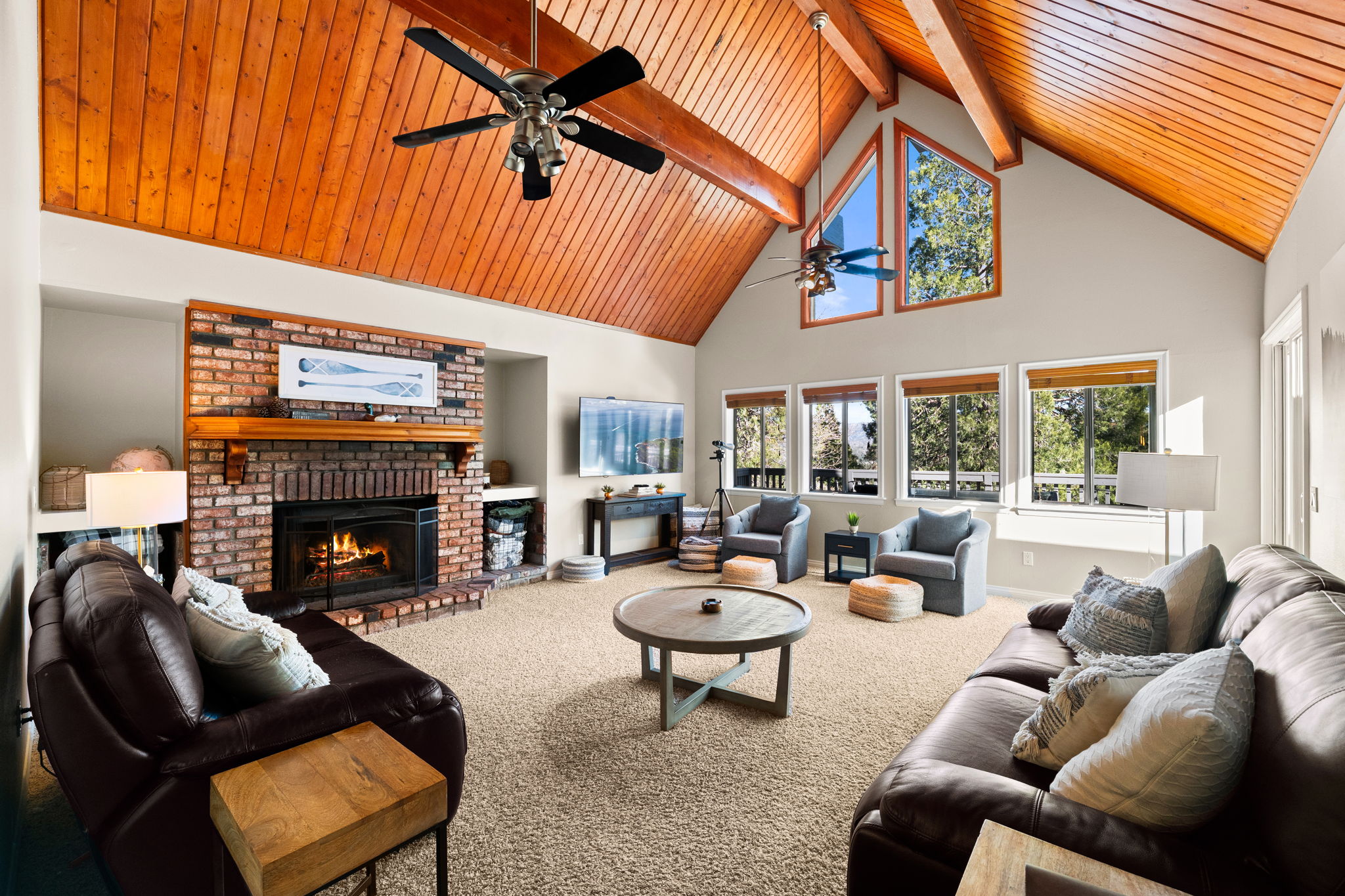 Vaulted great room with wood ceiling, large windows, and fireplace